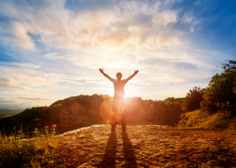 Person worshipping at sunrise